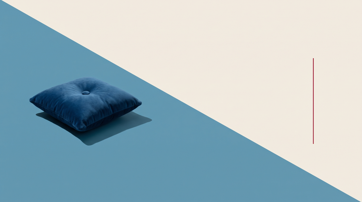Un cuscinetto di velluto blu con un rilievo, su fondo diviso in diagonale fra azzurro e bianco osso