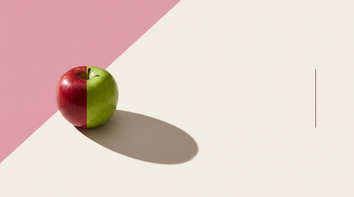 Una mela per metà rossa e per metà verde su fondo bianco osso attraversato da una diagonale rosa