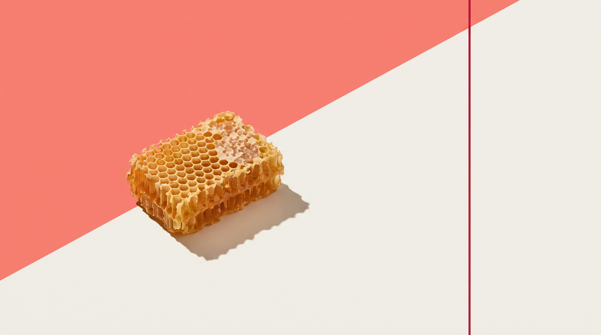 Favo di cera d'api su fondo corallo e bianco osso